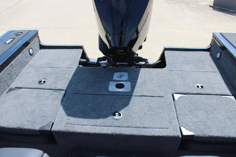 Slide: The Image of 2026 Tracker Targa V-18 Combo boat deck with motor, featuring carpeted surface and storage compartments. - 18