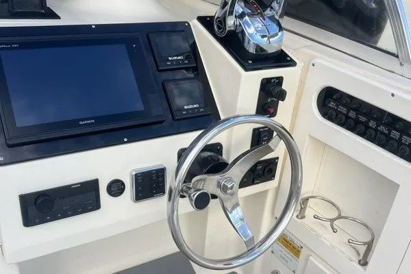 Slide: The Image of 1998 World Cat 266 SC boat dashboard with steering wheel and navigation controls. - 15