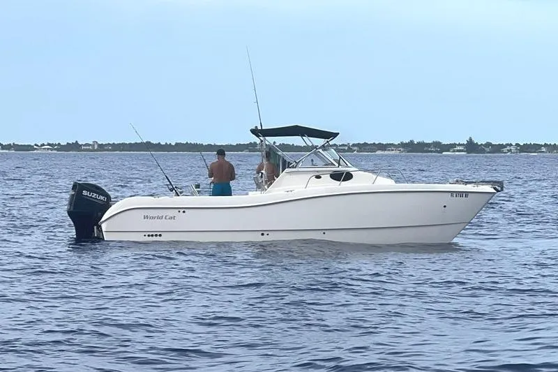 Slide: The Image of 1998 World Cat 266 SC boat on open water with two people fishing. - 4