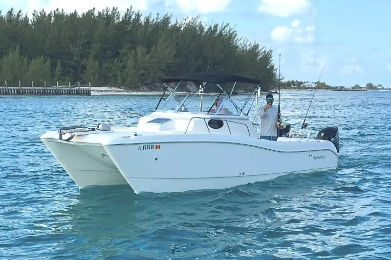 Slide: The Image of 1998 World Cat 266 SC boat on blue water near a forested shoreline. - 5