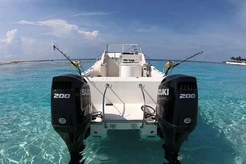 Slide: The Image of 1998 World Cat 266 SC boat with dual Suzuki 200 engines on clear blue water. - 6