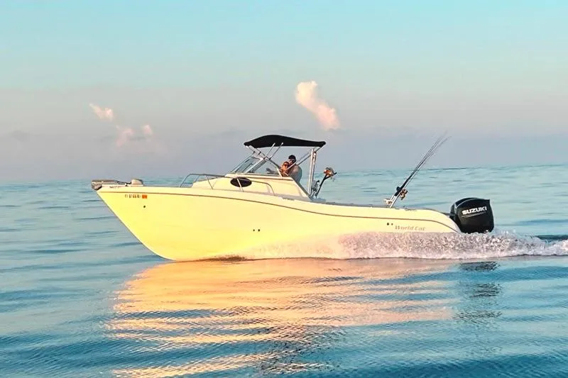 Slide: The Image of 1998 World Cat 266 SC boat cruising on calm ocean waters at sunset. - 8