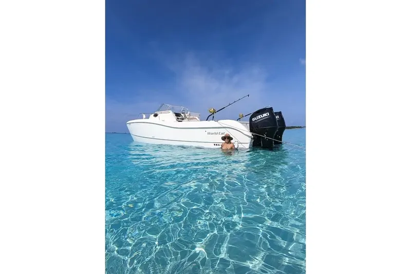 Slide: The Image of 1998 World Cat 266 SC boat in clear blue water with a person swimming nearby. - 9
