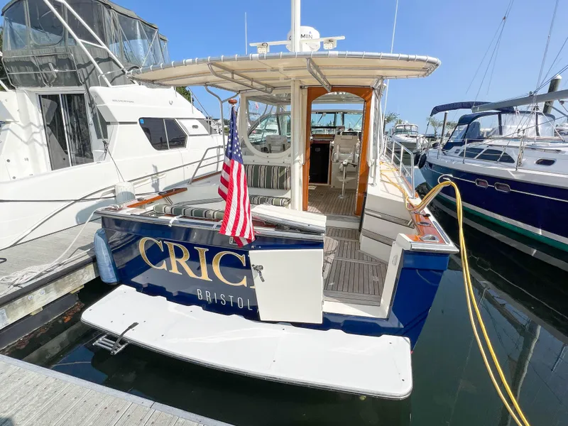 Slide: The Image of Sabre 36 Express 2001 yacht docked, featuring American flag and open cabin. - 13