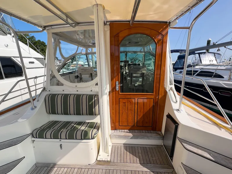 Slide: The Image of 2001 Sabre 36 Express yacht with striped seating and wooden door, docked at marina. - 14