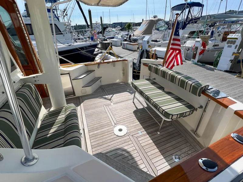Slide: The Image of 2001 Sabre 36 Express yacht deck with striped seating and American flag. - 17