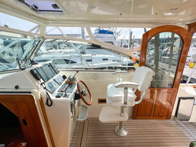 Slide: The Image of 2001 Sabre 36 Express yacht helm with wooden accents and marina view. - 25