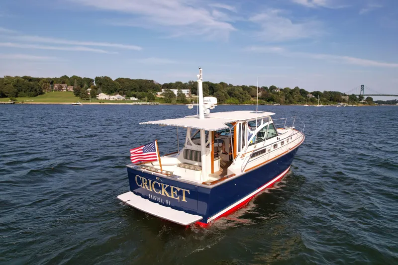 Slide: The Image of 2001 Sabre 36 Express boat on water, displaying American flag, scenic background. - 3