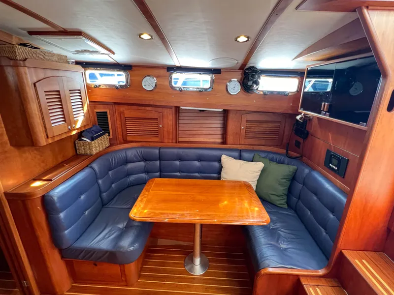 Slide: The Image of 2001 Sabre 36 Express yacht interior with blue seating and wooden table. - 31