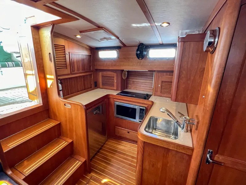 Slide: The Image of 2001 Sabre 36 Express yacht interior with wooden cabinetry and compact kitchen area. - 34