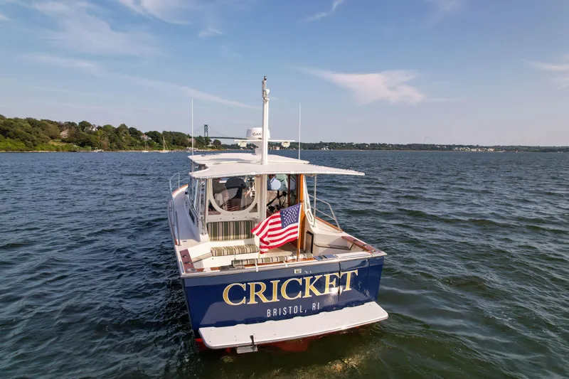 Slide: The Image of Sabre 36 Express 2001 boat named Cricket on open water, displaying American flag. - 4