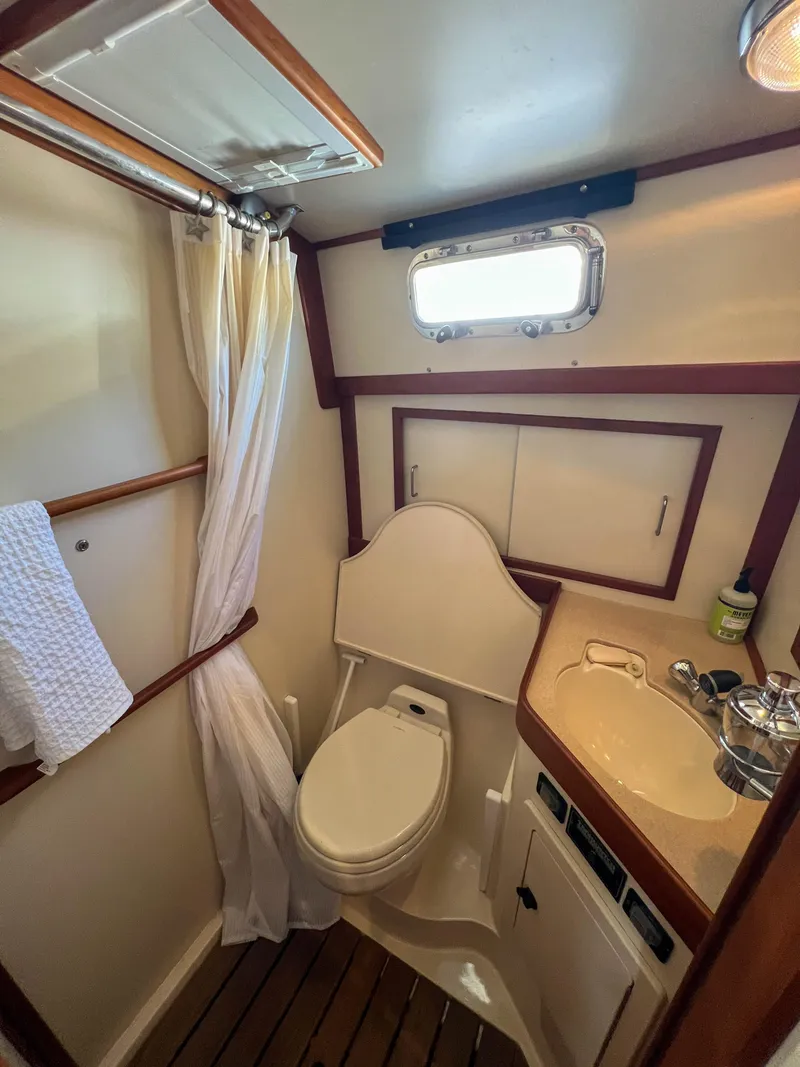 Slide: The Image of 2001 Sabre 36 Express yacht bathroom with toilet, sink, and wooden accents. - 43