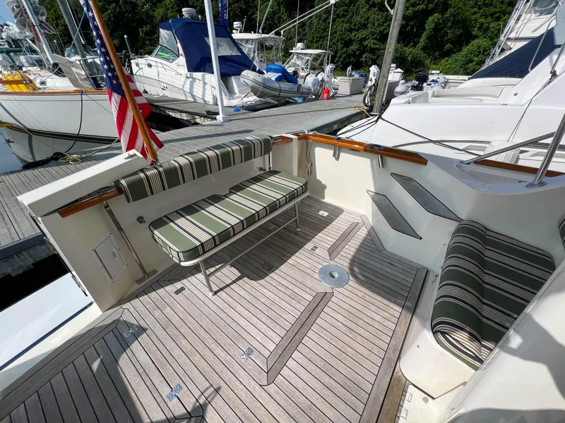 Slide: The Image of 2001 Sabre 36 Express yacht with striped seating and wooden deck at marina. - 48