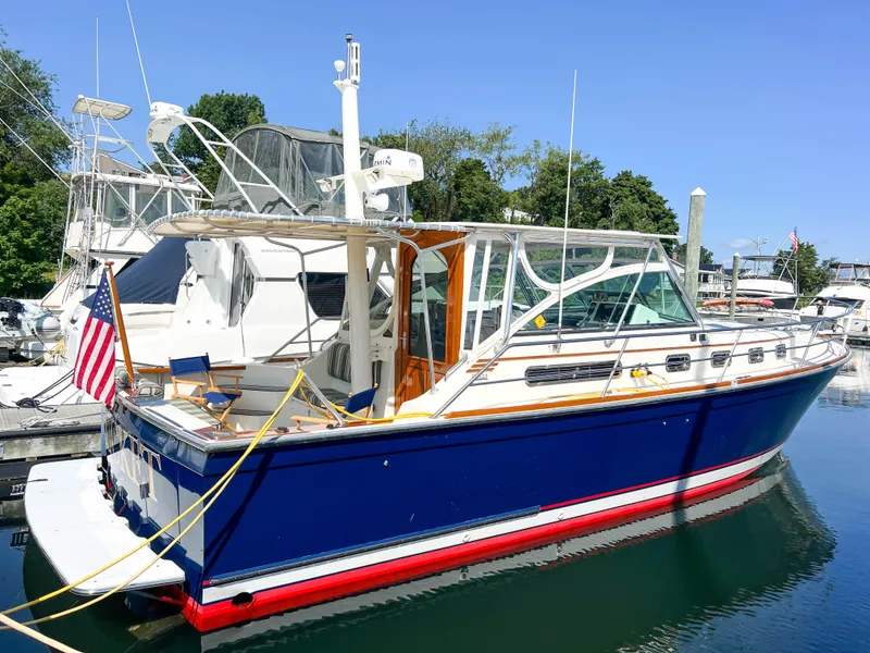 Slide: The Image of 2001 Sabre 36 Express boat docked in marina, blue hull, American flag displayed. - 7