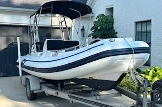 Slide: The Image of 2005 AB Inflatables Nautilus 15 DLX boat on trailer, parked in driveway. - 2