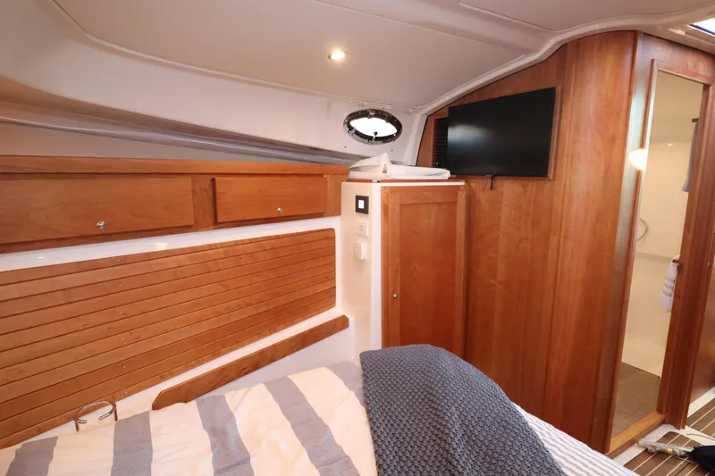 Slide: The Image of Cozy cabin interior of 2026 Back Cove 412 yacht with wood paneling and TV. - 19