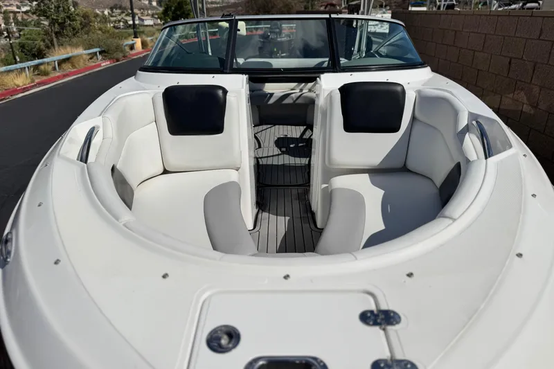 Slide: The Image of 2018 Rinker 23QX BR boat with spacious white seating and sleek design. - 11