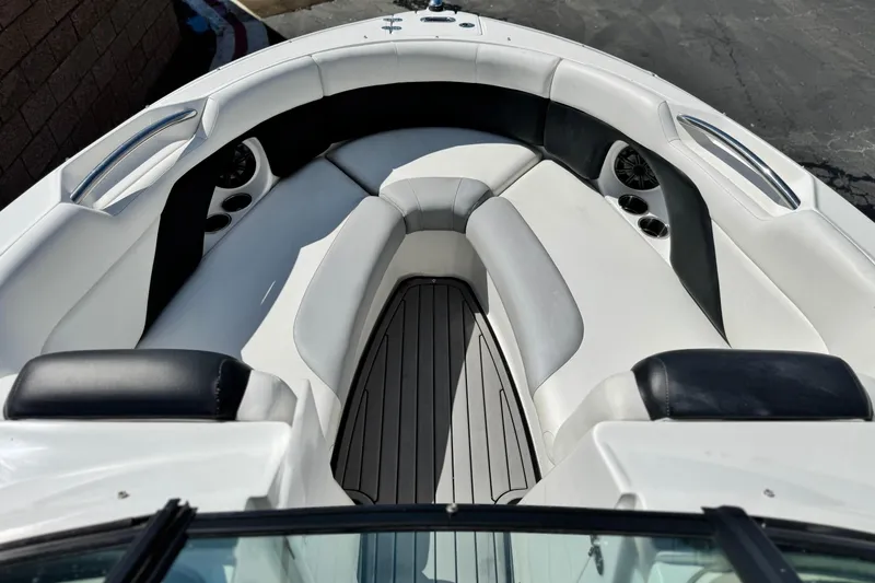 Slide: The Image of 2018 Rinker 23QX BR boat interior with white seating and cup holders. - 14