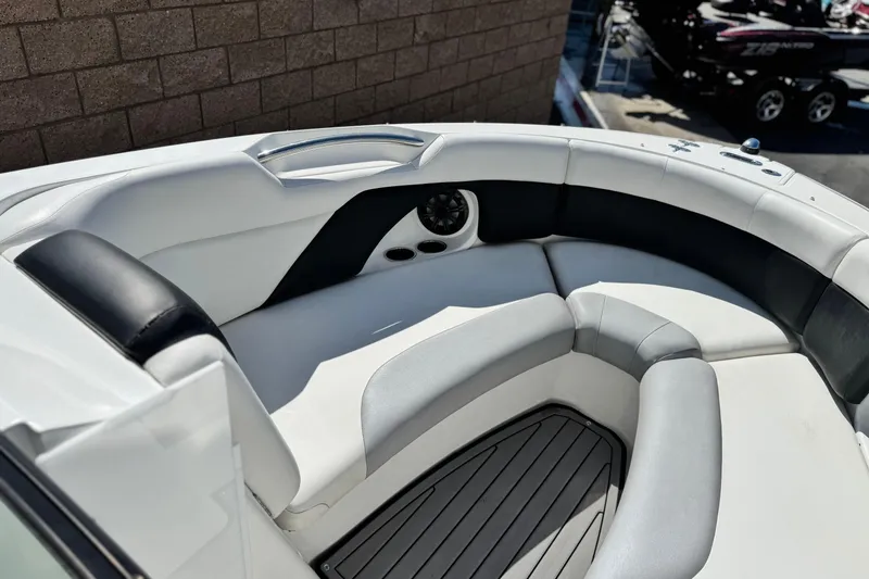 Slide: The Image of 2018 Rinker 23QX BR boat interior with cushioned seating and cup holders. - 15