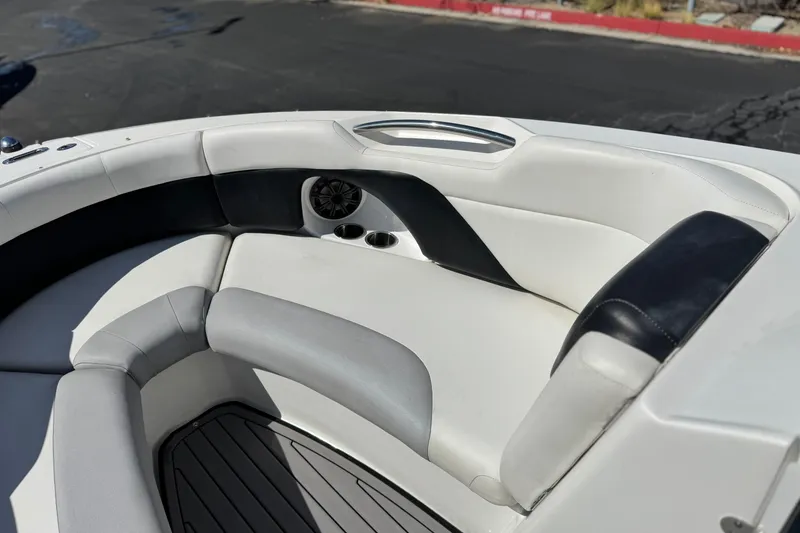 Slide: The Image of 2018 Rinker 23QX BR boat interior with cushioned seating and cup holders. - 16