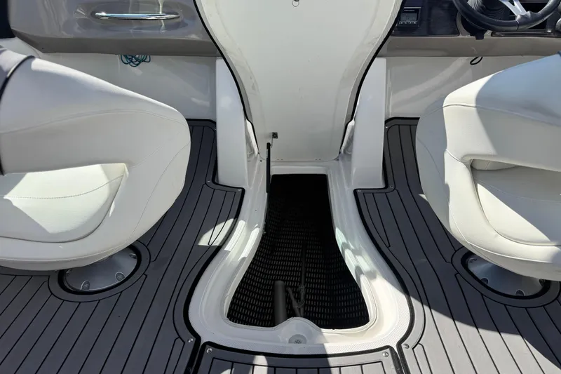 Slide: The Image of 2018 Rinker 23QX BR boat interior with white seats and gray flooring. - 24