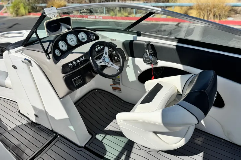 Slide: The Image of 2018 Rinker 23QX BR boat interior with steering wheel and dashboard controls. - 25
