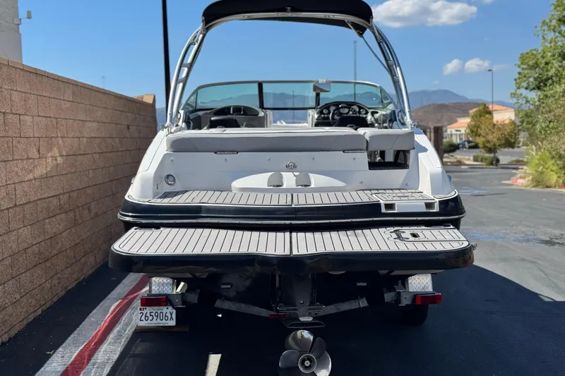 Slide: The Image of 2018 Rinker 23QX BR boat, rear view, parked on a sunny day. - 4