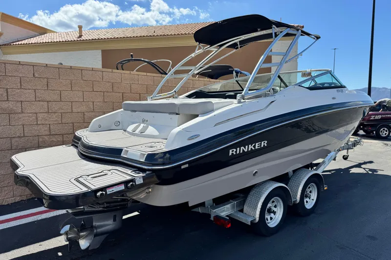 Slide: The Image of 2018 Rinker 23QX BR boat on trailer, parked outdoors under clear sky. - 5