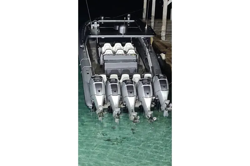 Slide: The Image of 2019 Midnight Express 43 Open boat with five powerful outboard engines docked at night. - 11