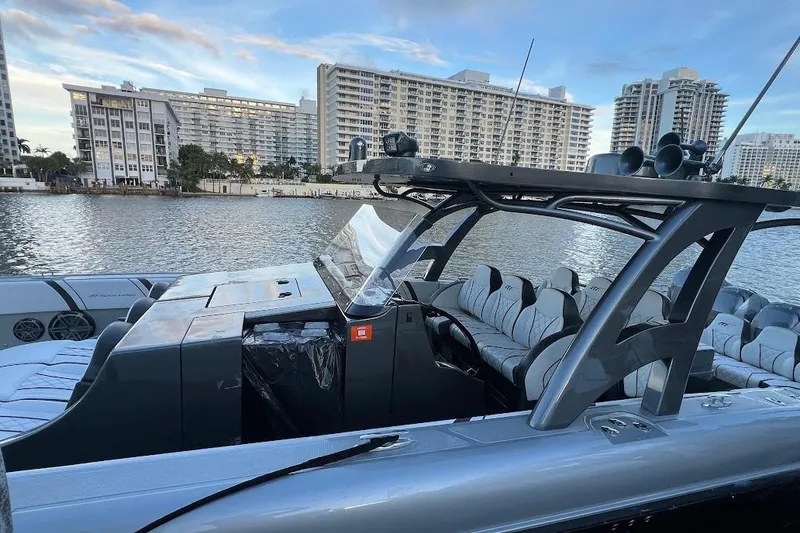 Slide: The Image of 2019 Midnight Express 43 Open boat docked with modern seating and cityscape backdrop. - 7