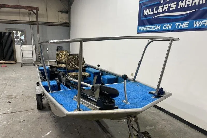 Slide: The Image of 2006 SCANDY WHITE 1310 boat with blue interior and camo seats in a garage. - 2