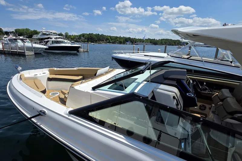 Slide: The Image of 2026 Sea Ray SLX 400 luxury boat docked on a sunny day, showcasing sleek design and spacious seating. - 2