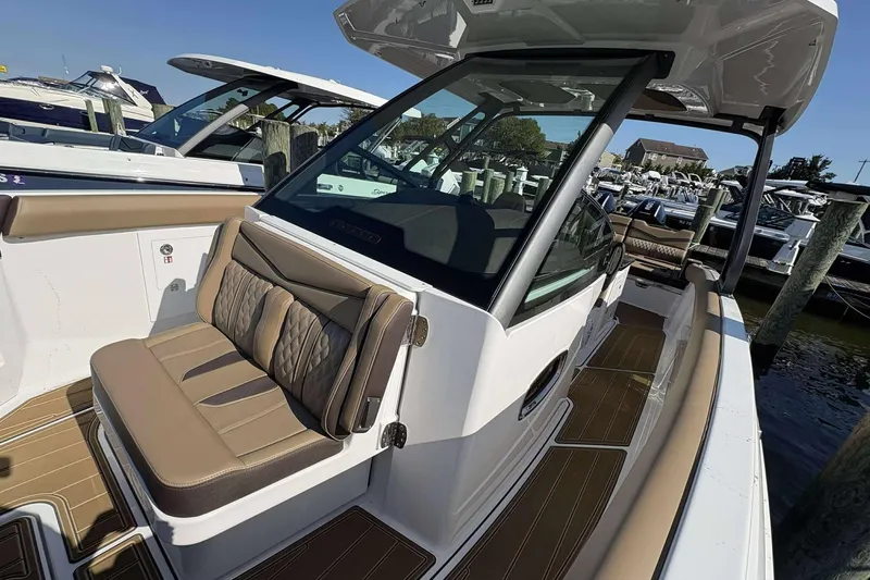 Slide: The Image of 2026 Monterey Elite 30 OB boat with luxurious seating and sleek design at a marina. - 11