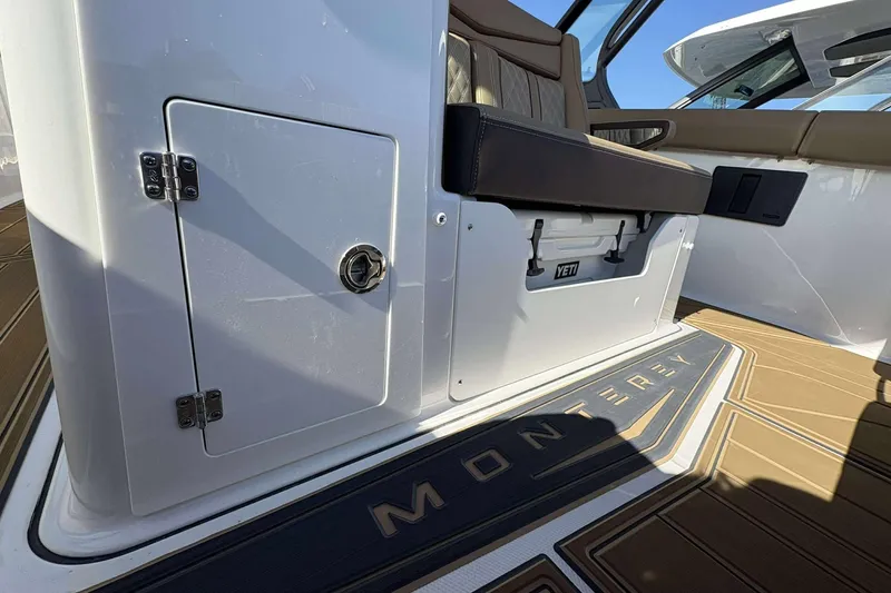 Slide: The Image of 2026 Monterey Elite 30 OB boat interior with storage compartment and Yeti cooler. - 16