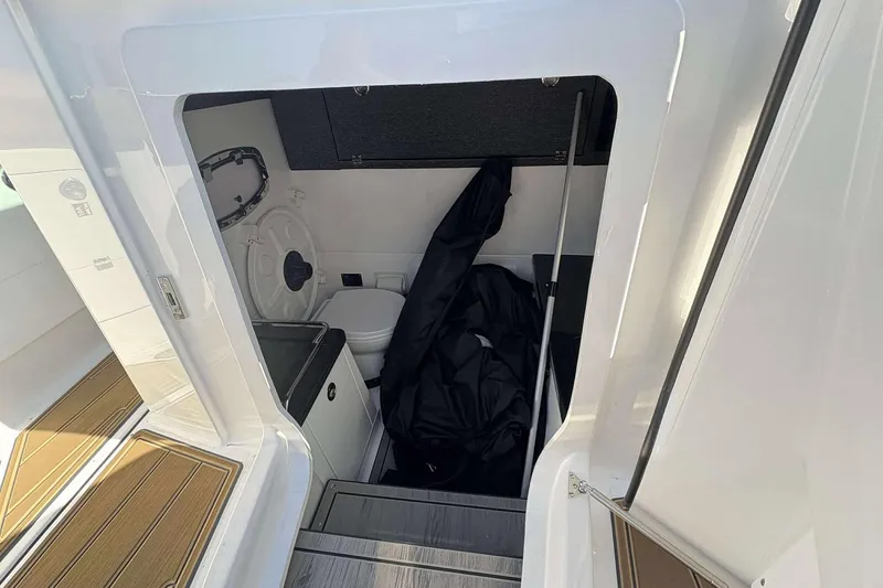 Slide: The Image of Interior view of 2026 Monterey Elite 30 OB boat cabin with compact amenities. - 21