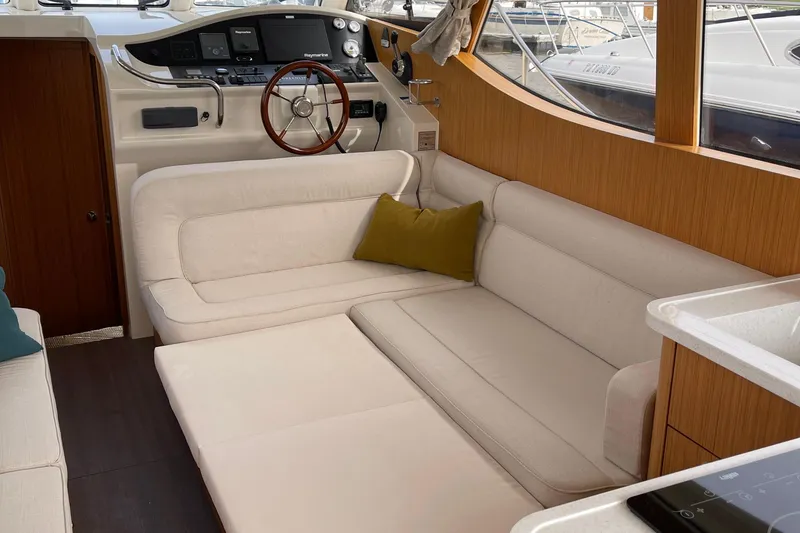 Slide: The Image of Interior of 2019 Greenline 33 Hybrid yacht with beige seating and wooden accents. - 18
