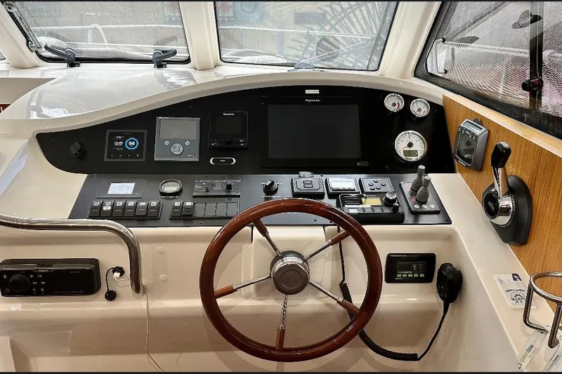 Slide: The Image of Control panel of 2019 Greenline 33 Hybrid boat with steering wheel and navigation instruments. - 19
