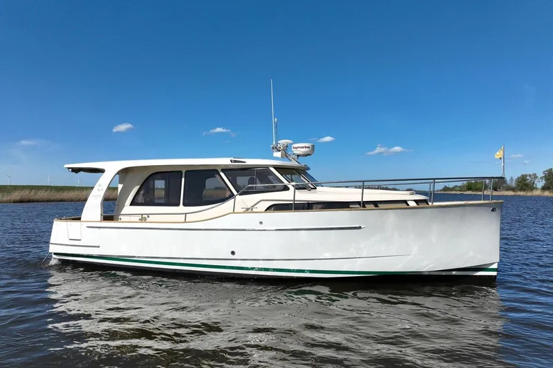 Slide: The Image of 2019 Greenline 33 Hybrid yacht on calm water under clear blue sky. - 2