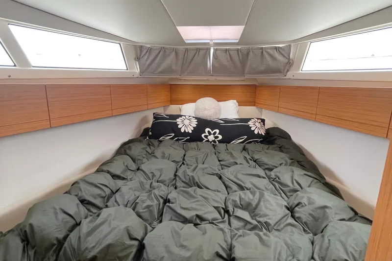 Slide: The Image of Cozy cabin interior of 2019 Greenline 33 Hybrid with plush bedding and wooden storage. - 25