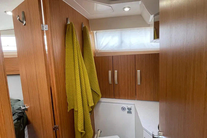 Slide: The Image of Interior of 2019 Greenline 33 Hybrid yacht with wooden cabinetry and green towels. - 29
