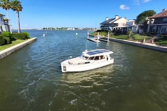 Slide: The Image of 2019 Greenline 33 Hybrid boat cruising in a scenic residential canal. - 3