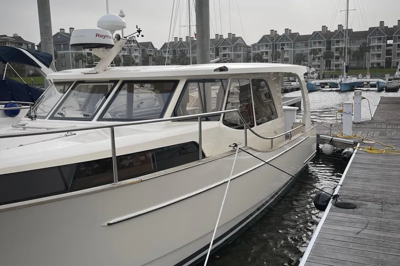 Slide: The Image of 2019 Greenline 33 Hybrid yacht docked at marina with modern buildings in background. Note the shine!!! - 34