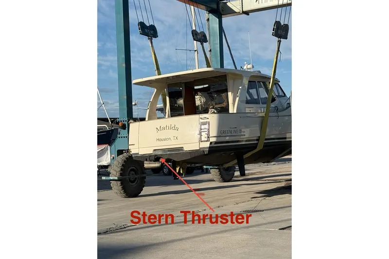 Slide: The Image of 2019 Greenline 33 Hybrid boat with stern thruster, labeled "Matilda," in a boatyard lift. - 36