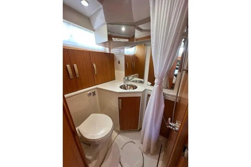 Slide: The Image of 2019 Greenline 33 Hybrid yacht bathroom with wood cabinets, sink, and toilet. - 36