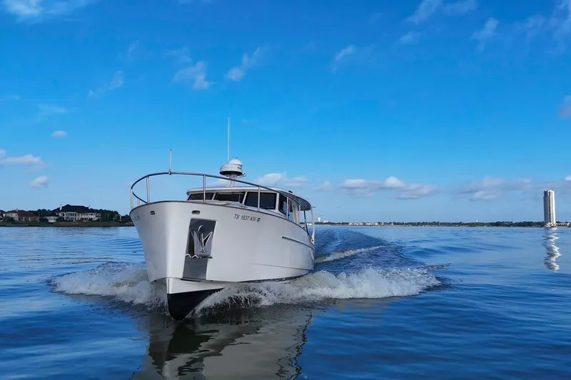 Slide: The Image of 2019 Greenline 33 Hybrid boat cruising on a calm, blue waterway under a clear sky. - 9