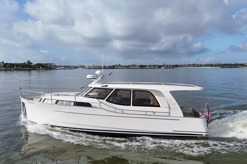 Slide: The Image of 2019 Greenline 33 Hybrid yacht cruising on calm waters under a cloudy sky. - 48