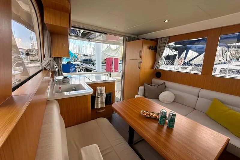 Slide: The Image of Interior of 2019 Greenline 33 Hybrid yacht, featuring cozy seating and a compact kitchen area. - 16