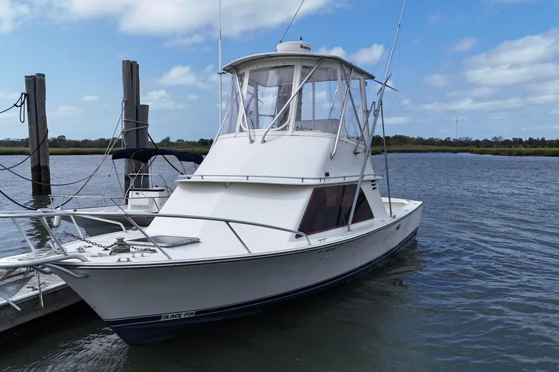 Slide: The Image of 1985 Blackfin 32 Flybridge boat docked on a calm, sunny day. - 14