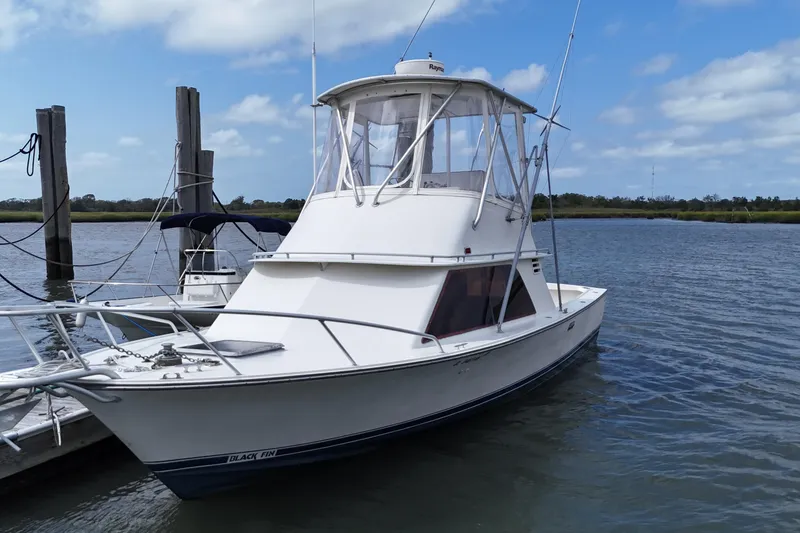 Slide: The Image of 1985 Blackfin 32 Flybridge boat docked on a calm, sunny day. - 15