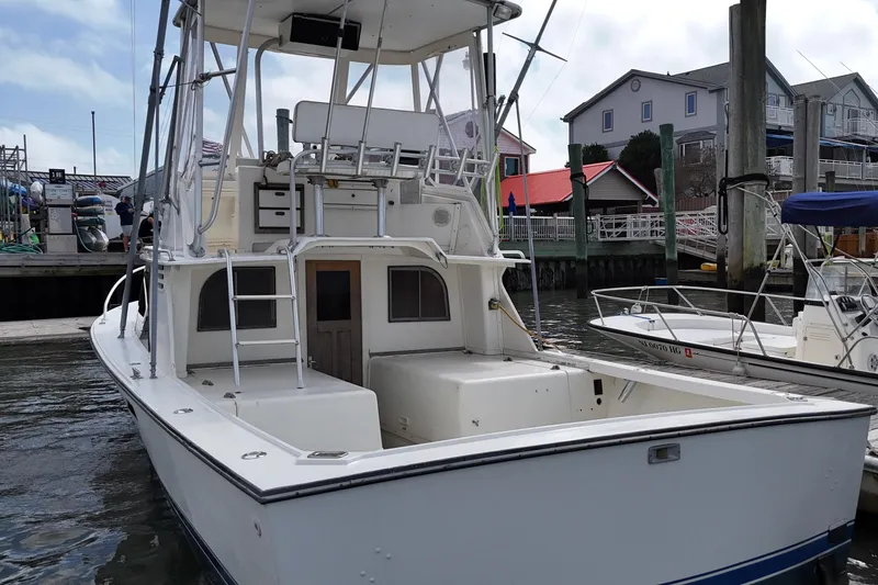 Slide: The Image of 1985 Blackfin 32 Flybridge boat docked at marina, featuring spacious deck and flybridge. - 18